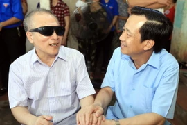 Bộ trưởng Đào Ngọc Dung thăm hỏi, tặng quà thương binh nặng Phạm Hữu Chung ở xóm Sơn Đô, xã Tân Thái, huyện Đại Từ, Thái Nguyên. (Ảnh: Anh Tuấn/TTXVN)