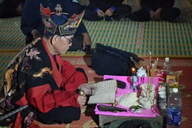 Một thầy Tào đang khấn lễ bằng chữ Nôm Tày. (Ảnh: Đức Hiếu/TTXVN)