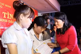 Lãnh đạo Thành phố Hồ Chí Minh và các doanh nghiệp trao tặng quà và tấm vé nghĩa tình cho công nhân về quê đón Tết. (Ảnh: Thanh Vũ/TTXVN)