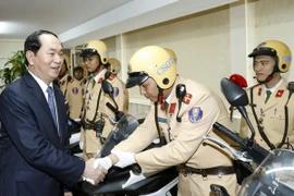 Chủ tịch nước Trần Đại Quang với các chiến sỹ Cảnh sát giao thông đang chuẩn bị lên đường làm nhiệm vụ. (Ảnh: Nhan Sáng/TTXVN)