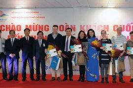 Đại diện lãnh đạo Thành phố Hồ Chí Minh với đoàn khách du lịch quốc tế đầu tiên. (Ảnh: An Hiếu/TTXVN)