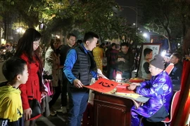 Xin chữ đầu năm lấy may mắn. (Ảnh: Quốc Khánh/TTXVN)