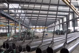 Công nhân kiểm tra ống thép inox chất lượng cao tại nhà máy ở huyện Ganyu, tỉnh Giang Tô, miền đông Trung Quốc. (Nguồn: THX/TTXVN)