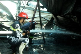 Lực lượng phòng cháy chữa cháy tham gia dập lửa. (Ảnh: Phước Ngọc/TTXVN)