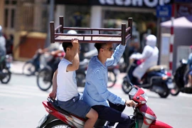 Người dân vi phạm giao thông vì nắng nóng. (Ảnh minh họa: Quý Trung/TTXVN)