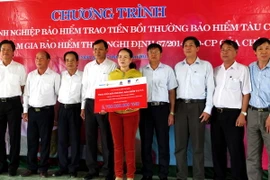 Đại diện 4 doanh nghiệp bảo hiểm trao bảng tượng trưng tiền bồi thường cho chủ tàu. (Ảnh: Sỹ Thắng/TTXVN)
