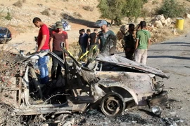 Người dân địa phương và các thành viên của tổ chức Hezbollah tại hiện trường một vụ đánh bom liều chết tại Liban. (Nguồn: AFP/TTXVN)