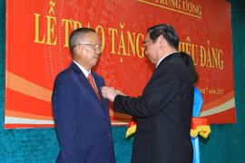 Ông Lê Hồng Anh, Ủy viên Bộ Chính trị, Thường trực Ban Bí thư gắn Huy hiệu 50 năm tuổi Đảng cho ông Trương Vĩnh Trọng. (Ảnh: Doãn Tấn/TTXVN)