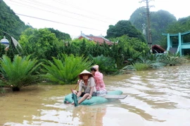 Nhiều phương tiện tự chế được sủ dụng để đi qua vùng nước ngập lụt tại dốc đèo Bụt, phường Hà Phon. (Ảnh: Minh Quyết/TTXVN)