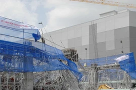 Lực lượng cứu hộ, cứu nạn đang tích cực tìm kiếm nạn nhân thứ 3 bị chôn vùi trong đống đổ nát. (Ảnh: Mạnh Linh/TTXVN)