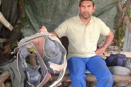 Một thành viên Hiệp hội làm sạch bờ biển đảo La Reunion (thuộc Pháp), đã tìm thấy một chiếc vali bị hỏng nặng tại Saint-Andre, đúng khu vực ông và các đồng nghiệp phát hiện mảnh vỡ nghi là của máy bay mất tích MH370. (Nguồn: AFP/TTXVN)