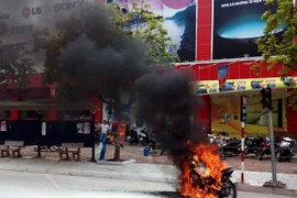 Hiện trường chiếc xe bốc cháy. (Ảnh: Thanh Tùng/TTXVN)