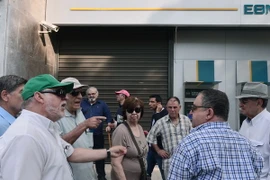 Người được hưởng trợ cấp và lĩnh lương hưu xếp hàng chờ đợi bên ngoài trụ sở Ngân hàng quốc gia Hy Lạp đã đóng cửa ở Athens ngày 29/6. (Nguồn: AFP/TTXVN)