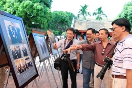 Các nhiếp ảnh gia và du khách xem triển lãm “Quan hệ Việt-Mỹ và nước Mỹ qua ống kính nhà nhiếp ảnh Việt Nam”. (Ảnh: An Đăng/TTXVN)