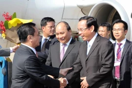 Phó Thủ tướng Nguyễn Xuân Phúc và Bộ trưởng, Chủ nhiệm Văn phòng Chính phủ Nguyễn Văn Nên đón Thủ tướng Lào Thongsing Thammavong tại sân bay Đà Nẵng. (Ảnh: Trần Lê Lâm/TTXVN)