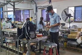 Công nhân Công ty TNHH Compass II tại Bình Dương chuẩn bị tâm thế 3 tại chỗ. (Ảnh: Chí Tưởng/TTXVN)