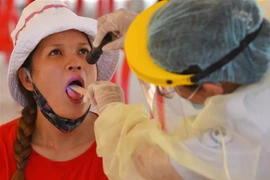 Nhân viên y tế lấy mẫu xét nghiệm cho người dân Phnom Penh, Campuchia. (Ảnh: AFP/TTXVN)