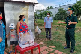 Thượng tá Doãn Đình Tránh, Phó Chính ủy Bộ Chỉ huy Bộ đội Biên phòng Kiên Giang, đến thăm, tặng quà bà con vùng biên giới. (Ảnh: TTXVN phát)