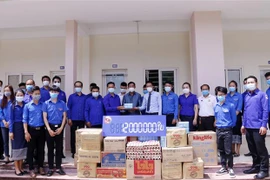 Chánh Văn phòng Trung ương Đoàn Thanh niên Lào, ông Souliya Kiewphilavong (trái) trao quà cho ông Trần Đại Thắng (áo sáng phải) Bí thư Ban Cán sự Đoàn TNCS Hồ Chí Minh tại Lào. (Ảnh: Phạm Kiên/TTXVN)