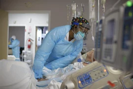 Nhân viên y tế chăm sóc bệnh nhân COVID-19. (Ảnh: AFP/TTXVN)