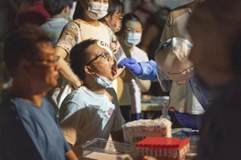 Nhân viên y tế lấy mẫu xét nghiệm COVID-19 cho người dân tại Vũ Hán, tỉnh Hồ Bắc, Trung Quốc. (Ảnh: THX/TTXVN)