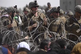 Binh sỹ Mỹ đảm bảo an ninh khi dòng người Afghanistan sơ tán lánh nạn đổ về tuyến đường gần khu quân sự của sân bay quốc tế Kabul. (Ảnh: AFP/TTXVN)