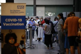 Người dân xếp hàng chờ tiêm vaccine ngừa COVID-19 tại London, Anh. (Ảnh: AFP/TTXVN)