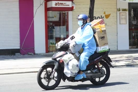 Một shipper trên đường đi giao hàng. (Ảnh: Văn Dũng/TTXVN)