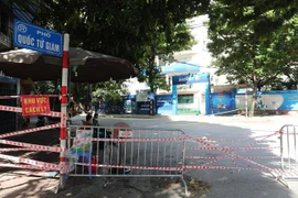 Lực lượng chức năng phường Văn Miếu lập rào phong tỏa phố Quốc Tử Giám sau khi có thông tin 22 ca dương tính mới. (Ảnh: Thành Đạt /TTXVN)