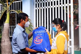 Đại diện Hội đồng Nhân dân Thành phố Hồ Chí Minh trao quà tặng và động viên công nhân ở trọ, người lao động có hoàn cảnh khó khăn ở Quận 8. (Ảnh: Thanh Vũ/TTXVN)