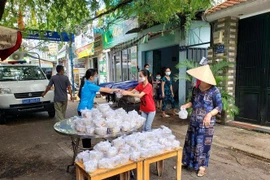 Đại diện Liên đoàn Lao động quận Gò Vấp trao Suất ăn nghĩa tình Công đoàn Gò Vấp cho công nhân ở trọ, người nghèo trong khu phong tỏa. (Ảnh: Thanh Vũ/TTXVN)