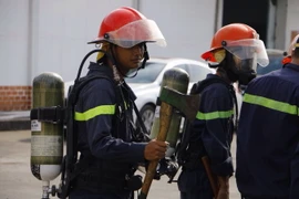 Lực lượng chữa cháy tiếp cận hiện trường. (Ảnh: Thanh Liêm/TTXVN)