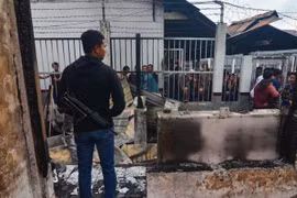 Một cảnh sát bảo vệ khu vực nhà tù ở khu vực Siak sau khi xảy ra vụ đốt trại giam. (Nguồn: AFP)