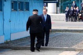 Tổng thống Hàn Quốc Moon Jae-in đón Nhà lãnh đạo Triều Tiên Kim Jong-un (trái) tại đường phân định ranh giới hai miền ở làng đình chiến Panmunjom. (Nguồn: YONHAP/TTXVN)