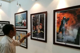 Khách tham quan triển lãm ảnh. (Ảnh: PV/Vietnam+)