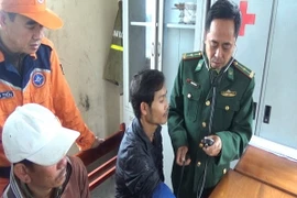 Quân y sỹ đồn Biên phòng Roòn chăm sóc sức khỏe cho thuyên viên gặp nạn. (Ảnh: Đức Thọ/TTXVN)
