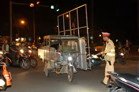 Cảnh sát giao thông Đội 14, Công an thành phố Hà Nội xử lý người điều khiển chở hàng quá khổ tại đường Giải Phóng, Hà Nội. (Ảnh: Doãn Tấn/TTXVN)