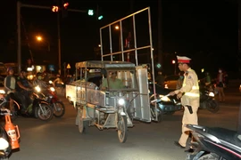Cảnh sát giao thông Đội 14, Công an thành phố Hà Nội xử lý người điều khiển chở hàng quá khổ tại đường Giải Phóng, Hà Nội. (Ảnh: Doãn Tấn/TTXVN)