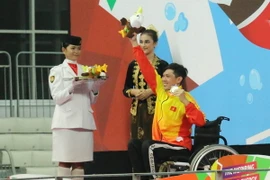 Võ Thanh Tùng (áo vàng) nhận huy chương bạc Asian Para Games 2018. (Ảnh: Hải Ngọc/TTXVN)