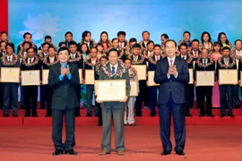 Chủ tịch nước Trần Đại Quang tặng hoa cho các Chủ tịch công đoàn cơ sở có thành tích đặc biệt xuất sắc. (Ảnh: Nhan Sáng/TTXVN) 