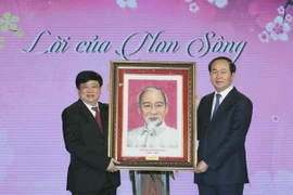 Chủ tịch nước Trần Đại Quang tặng bức tranh chân dung Chủ tịch Hồ Chí Minh cho Đài Tiếng nói Việt Nam. (Ảnh: Nhan Sáng/TTXVN)