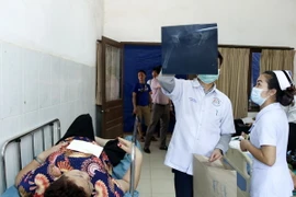 Các bác sỹ Lào chăm sóc cho các nạn nhân trong vụ tai nạn. (Ảnh: Phạm Kiên/TTXVN)
