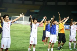 Olympic Việt Nam ăn mừng cùng người hâm mộ sau chiến thắng. (Ảnh: Hoàng Linh/TTXVN)