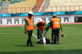 Nhân viên phục vụ đang dùng máy lu sơn lại vạch sân Wibawa Mukti. (Ảnh: Trọng Tuệ/TTXVN)