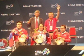 Lê Văn Công (giữa) nhận huy chương vàng tại ASEAN Para Games 2017. (Ảnh: Hoàng Nhương/TTXVN)