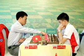 Kỳ thủ Lê Quang Liêm (trái) đấu ván thứ tư với Nguyễn Anh Khôi. (Ảnh: Hoàng Hải/Vietnam+)