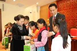 Chủ tịch Quốc hội Nguyễn Thị Kim Ngân tặng quà cho các cháu thiếu nhi. (Ảnh: Trọng Đức/TTXVN)