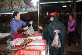 Người tiêu dùng mua mực tại chợ thành phố Hà Tĩnh. (Ảnh: Phan Quân/TTXVN)