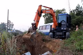 Lực lượng chức năng tiến hành tiêu hủy 2,8 tấn thực phẩm nhập lậu không rõ nguồn gốc. (Ảnh: Nguyễn Hoàng/TTXVN)