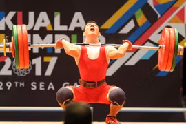 VĐV Thạch Kim Tuấn thi đấu chung kết nội dung Cử tạ hạng 56 kg nam. (Ảnh: Quốc Khánh/TTXVN)